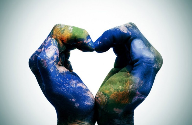 Hands in the shape of a heart, painted with a map of Earth